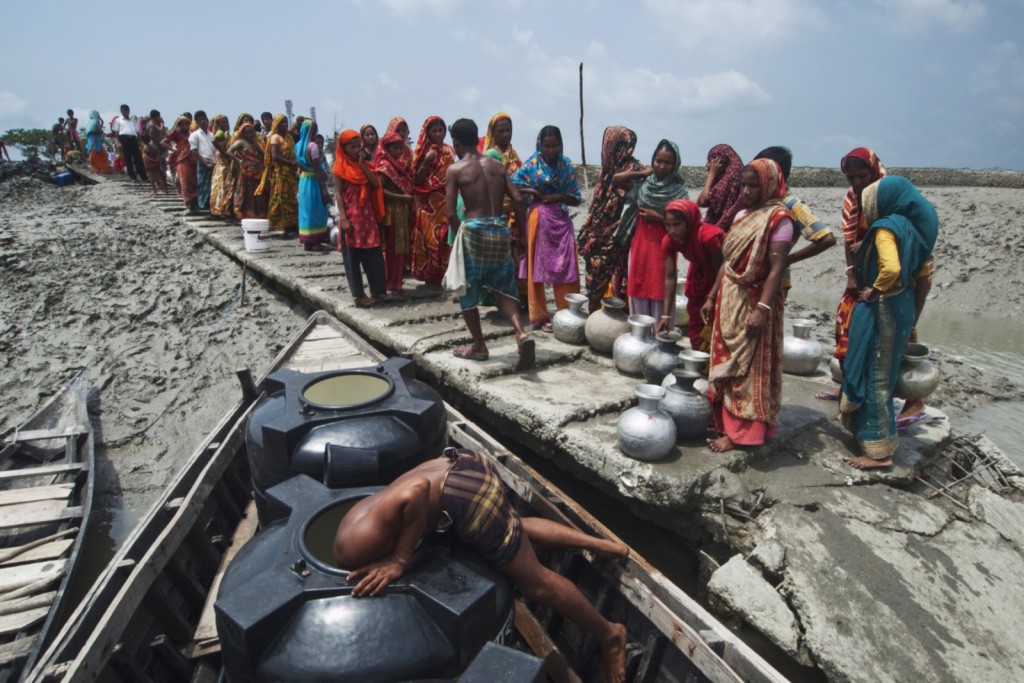 Potable water is delivered by barge to a cyclone affected area.